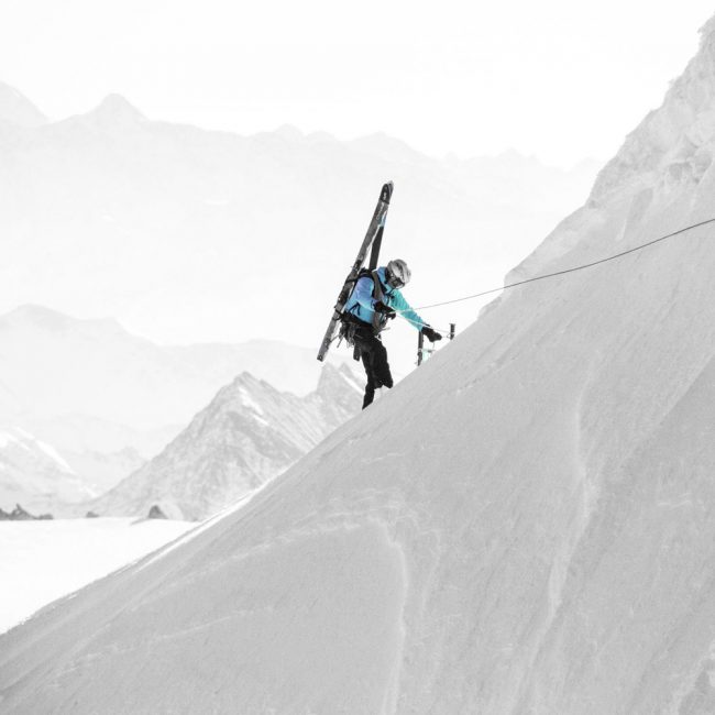 Alpiniste en train de monter le flanc d'une montagne