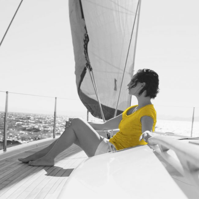 femme assise sur un voilier, cheveux aux vents